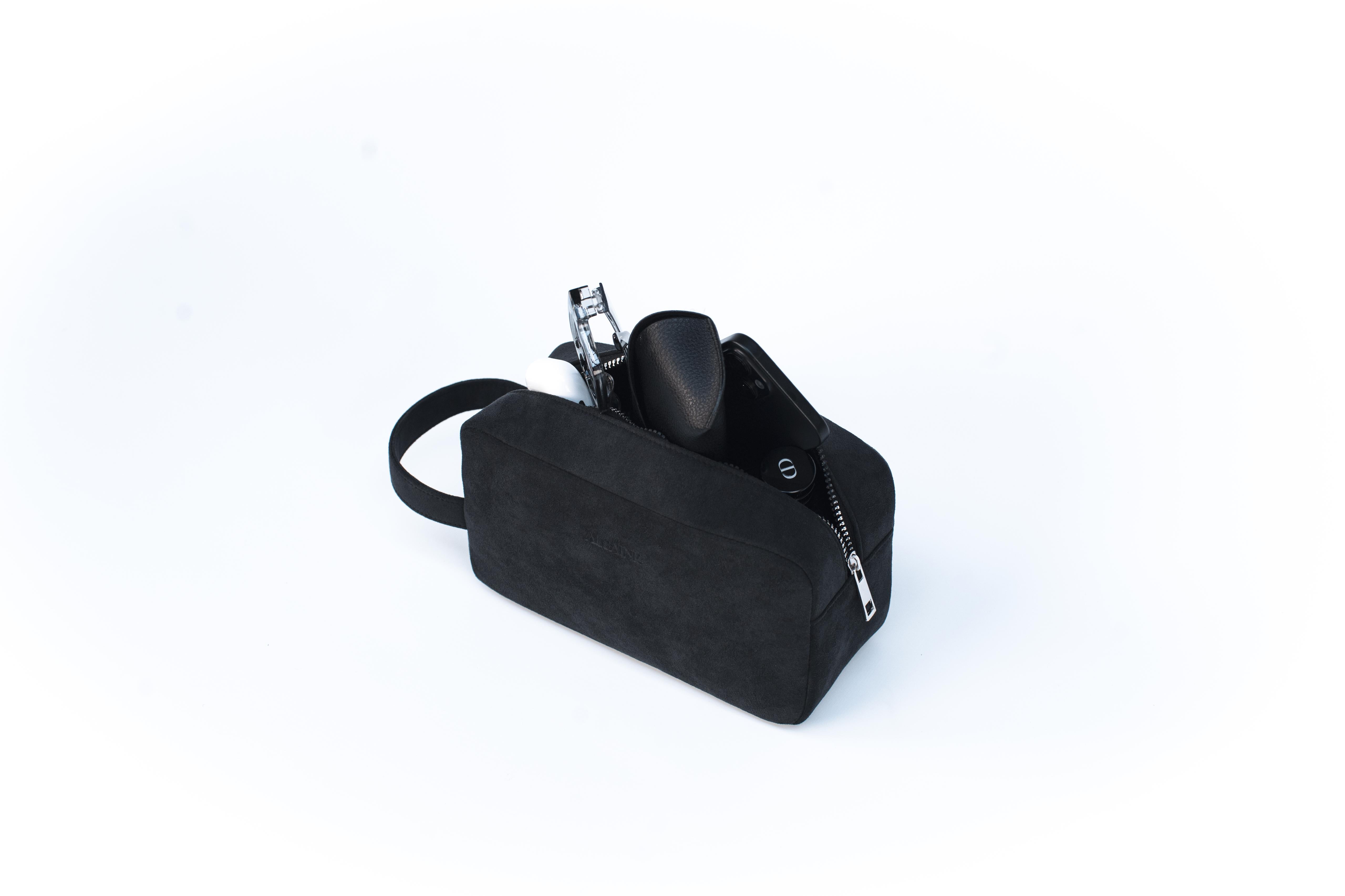 Luxe Alcantara toilettas open met reisessentials