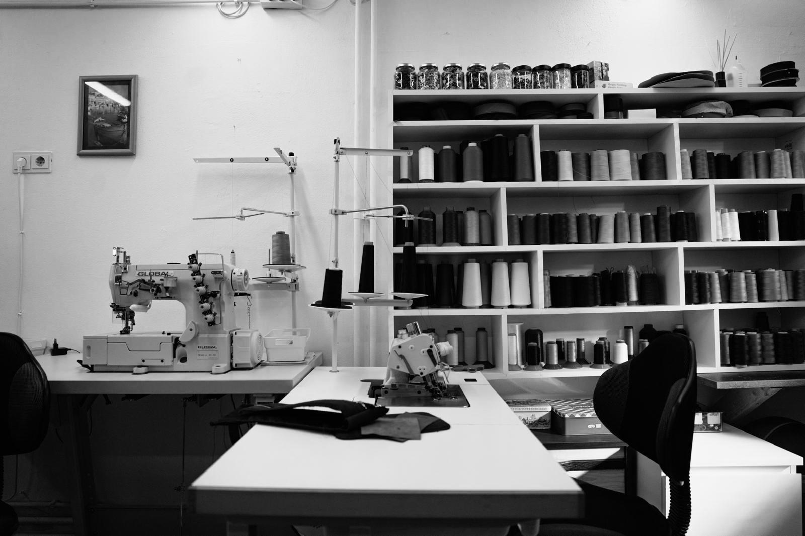 Handgemaakt: een vakman plaatst een Alsaine Alcantara toilettas onder de naaimachine tijdens het productieproces
